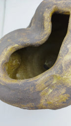 Vase noir et or en forme de goutte, ouverture ovale creusée, intérieur doré.
