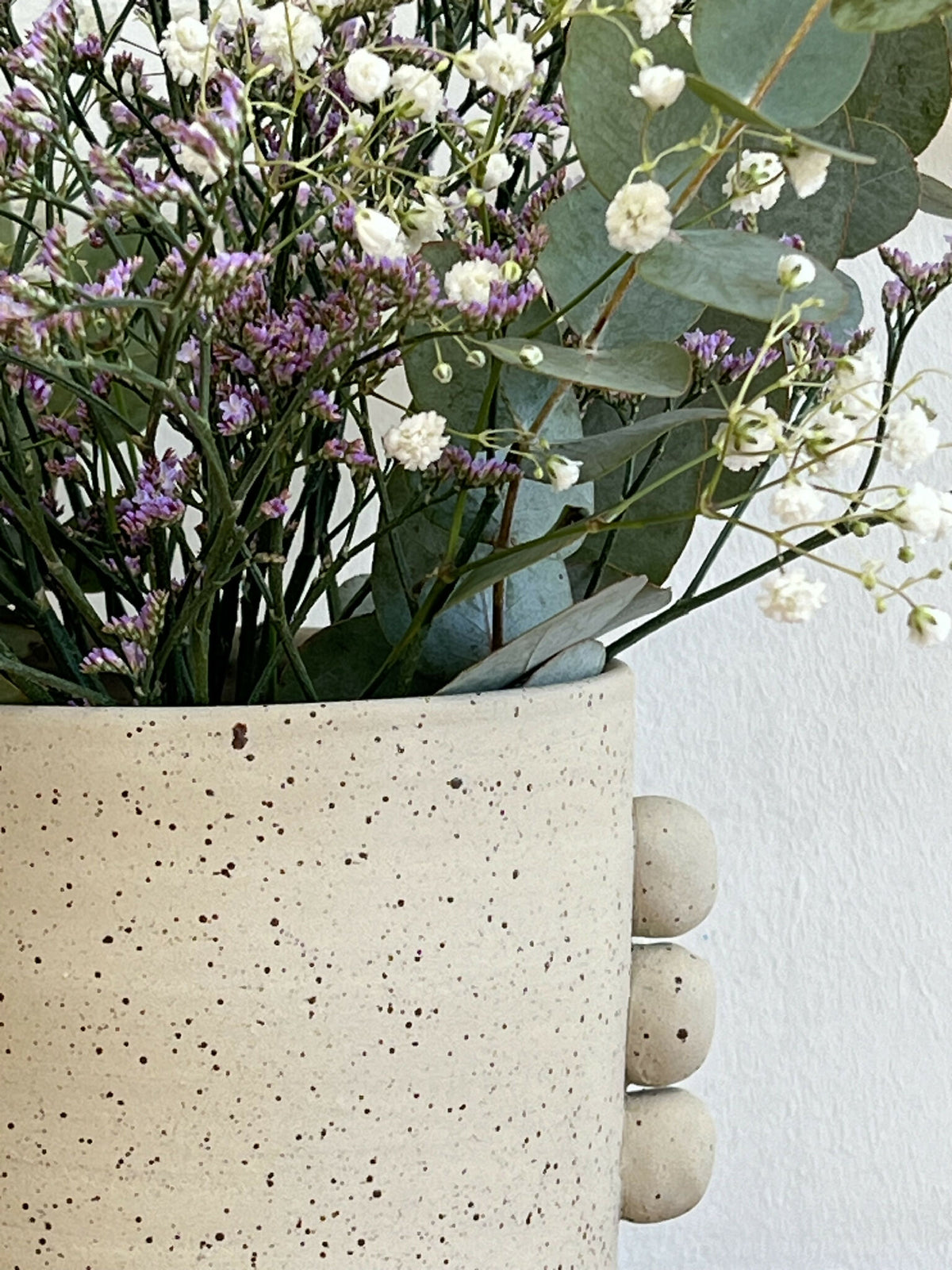 Vase en grès beige tacheté, gros reliefs arrondis sur la base, bord supérieur lisse.