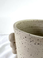Vase en grès beige specklé, bord évasé, anses rondes en relief sur le côté.