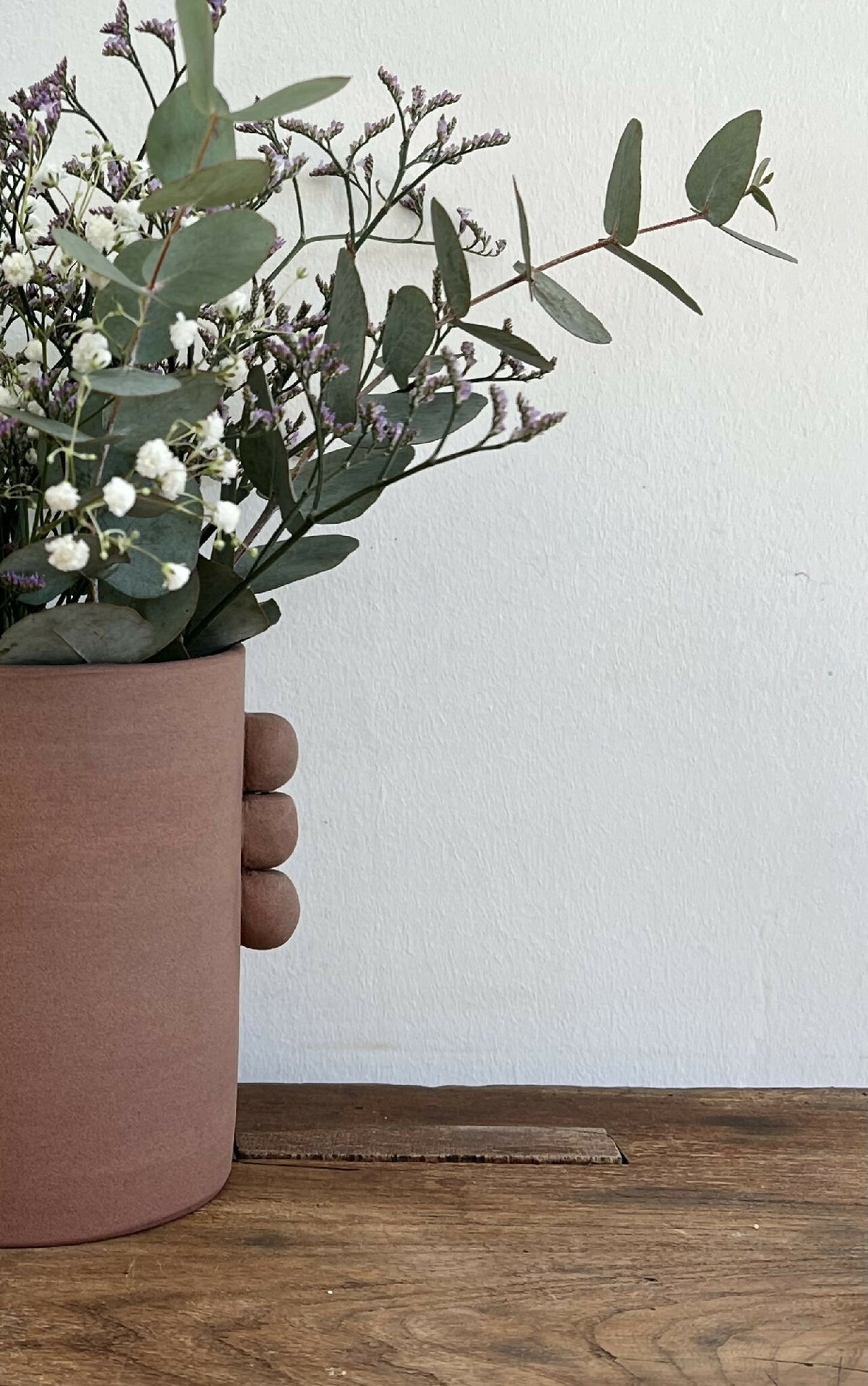 Vase cylindrique rose avec anses rondes en relief, base plate, finition mate.