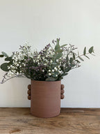 Vase en grès roux PALMA, bouquet de fleurs blanches et mauves, tiges et feuilles visibles.