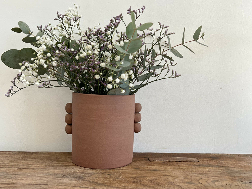 Vase en grès roux PALMA, bouquet de fleurs blanches et mauves avec feuilles d’eucalyptus.