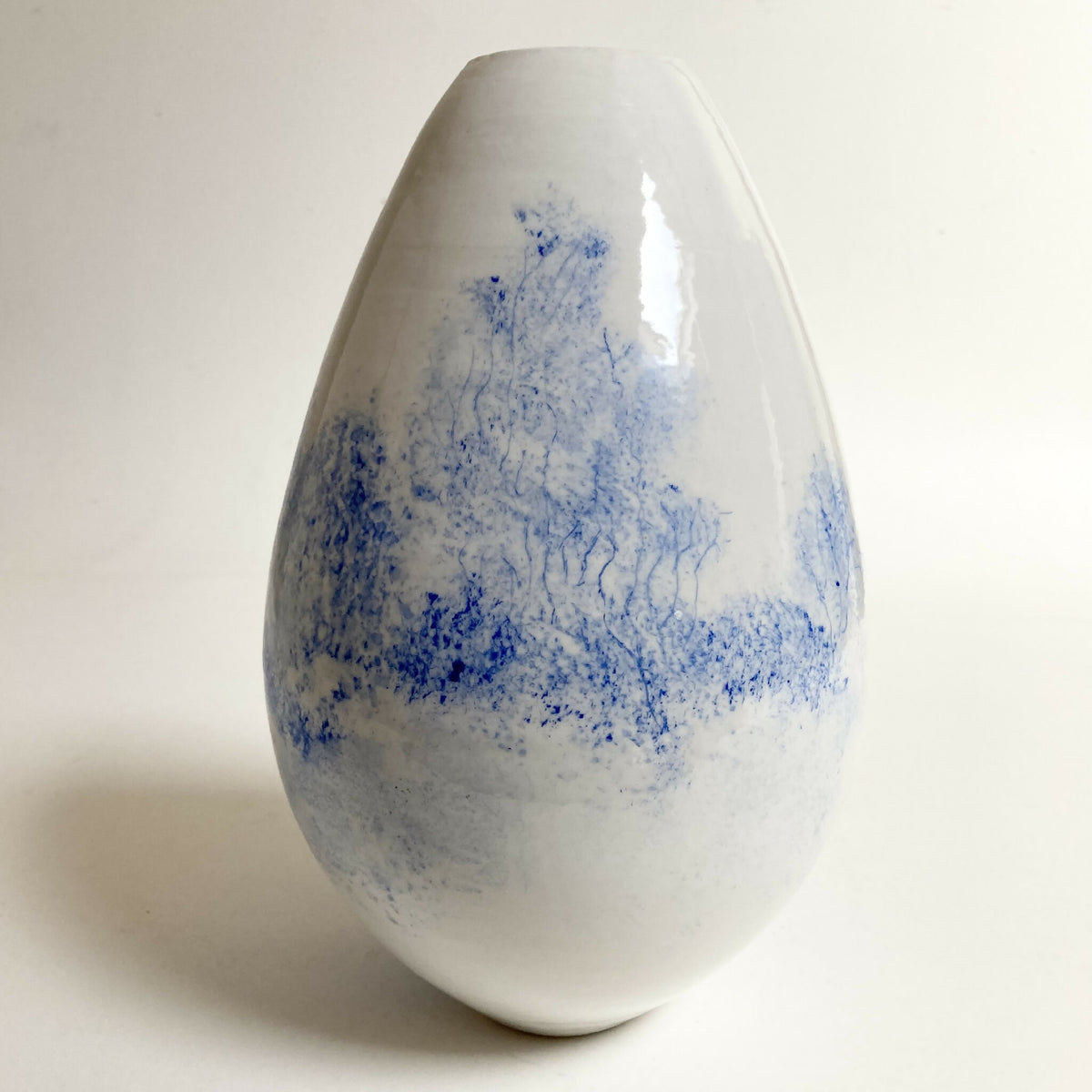 Vase en porcelaine blanc au décor bleu de paysage arboré, forme goutte