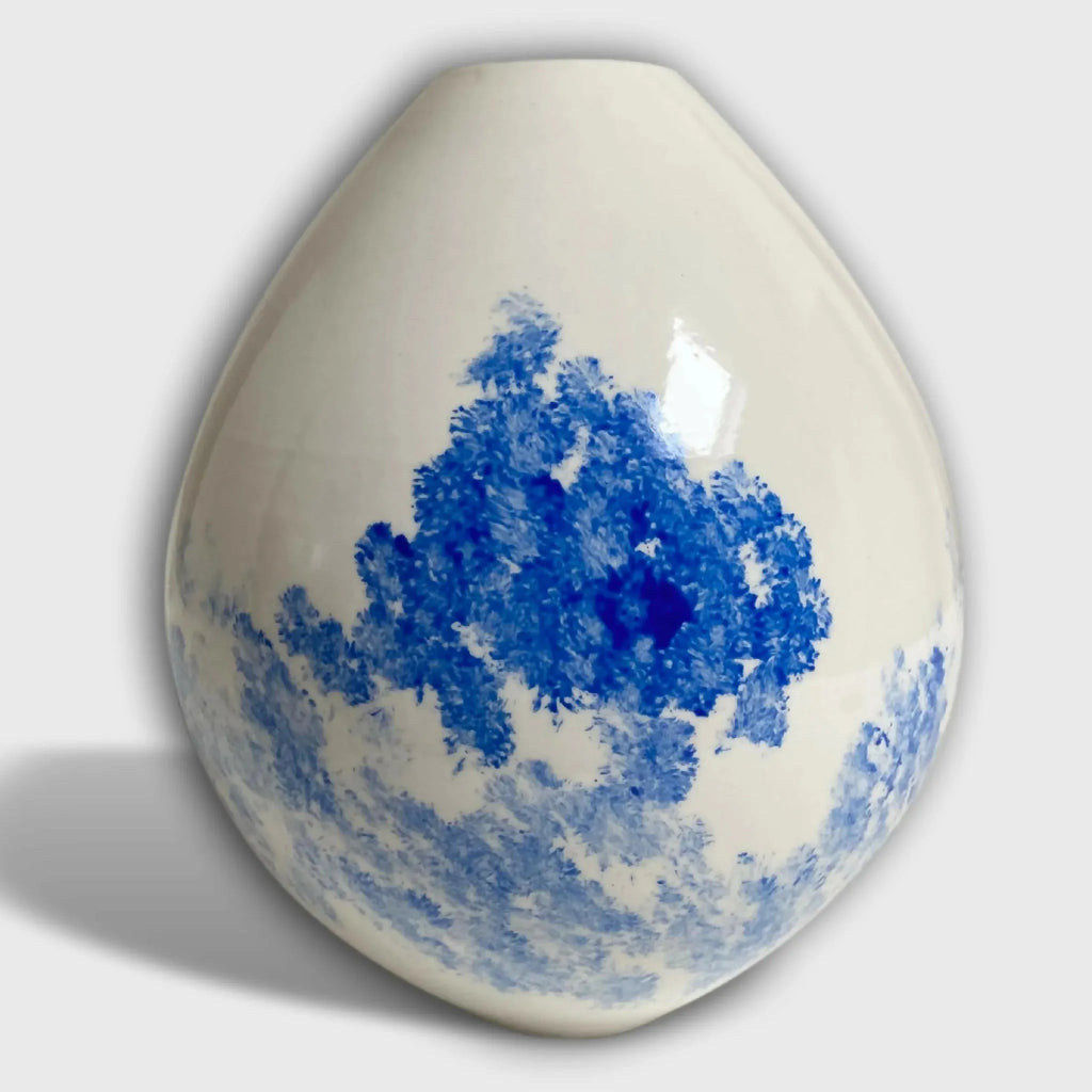 Vase en céramique goutte blanche avec paysage bleu, vue de face.