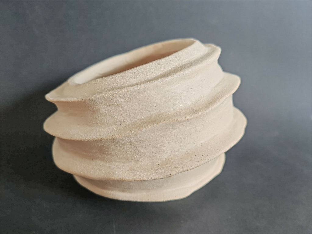Vase sculptural blanc cassé, spirale d’anneaux superposés vue de profil