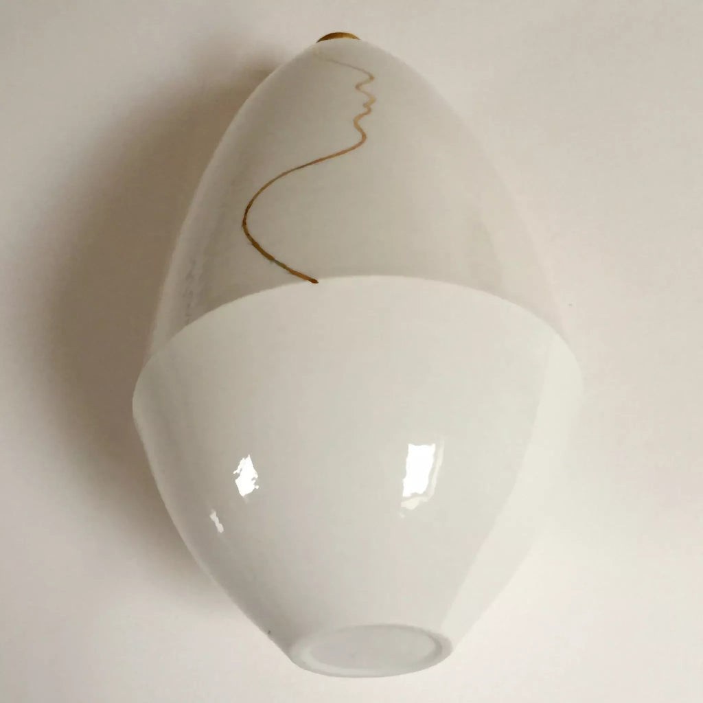Vase soliflore blanc, vue en biais du goulot et du dessin visage doré