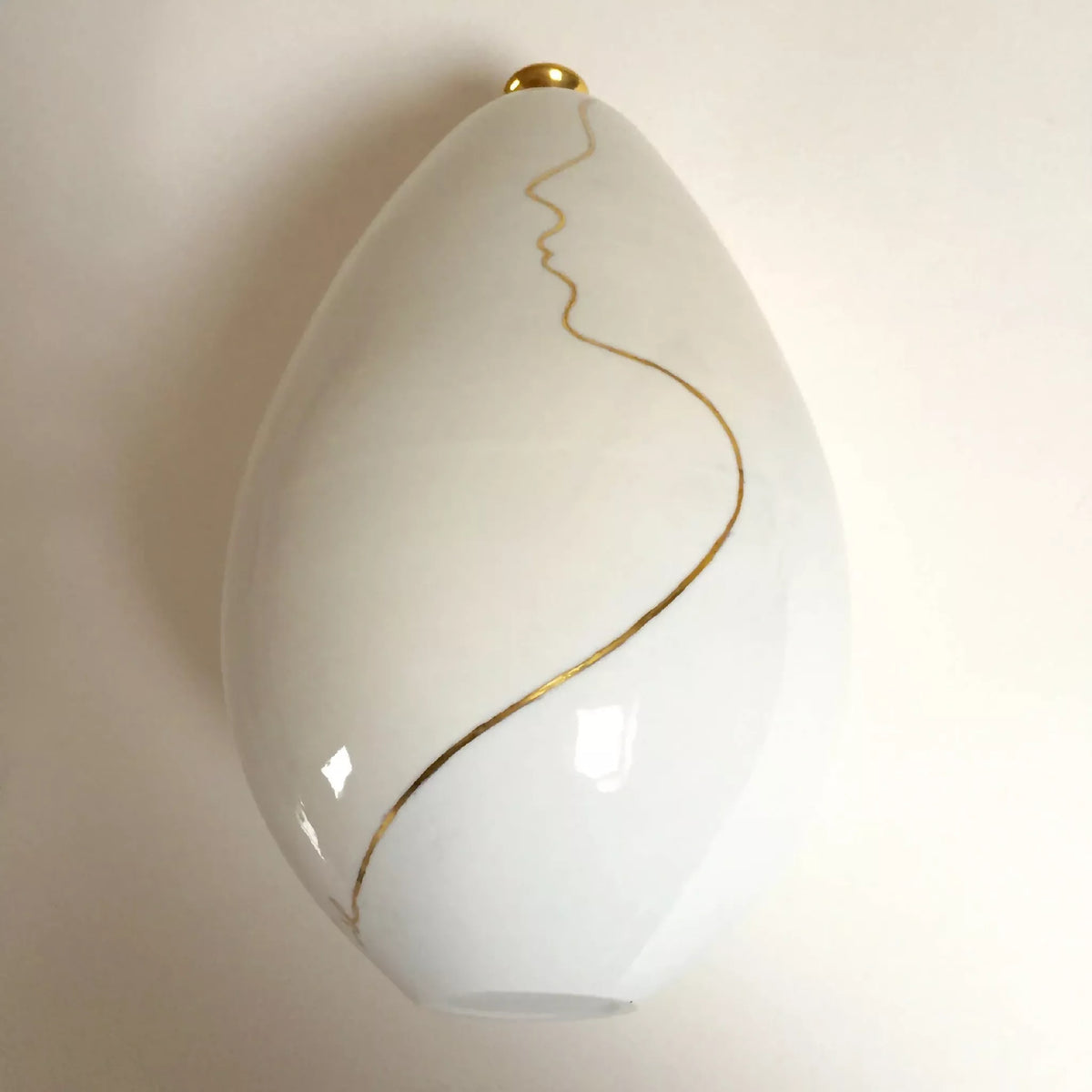 Vase soliflore blanc en forme de goutte, trait doré ondulé sur la panse.