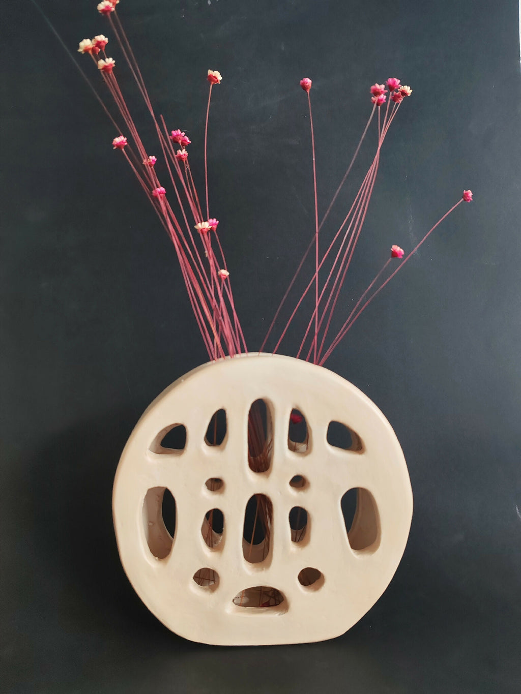 Vase SOUFFLE BLANC perforé à trous ovales, avec tiges et fleurs rouges