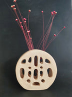 Vase SOUFFLE BLANC perforé à trous ovales, avec tiges et fleurs rouges