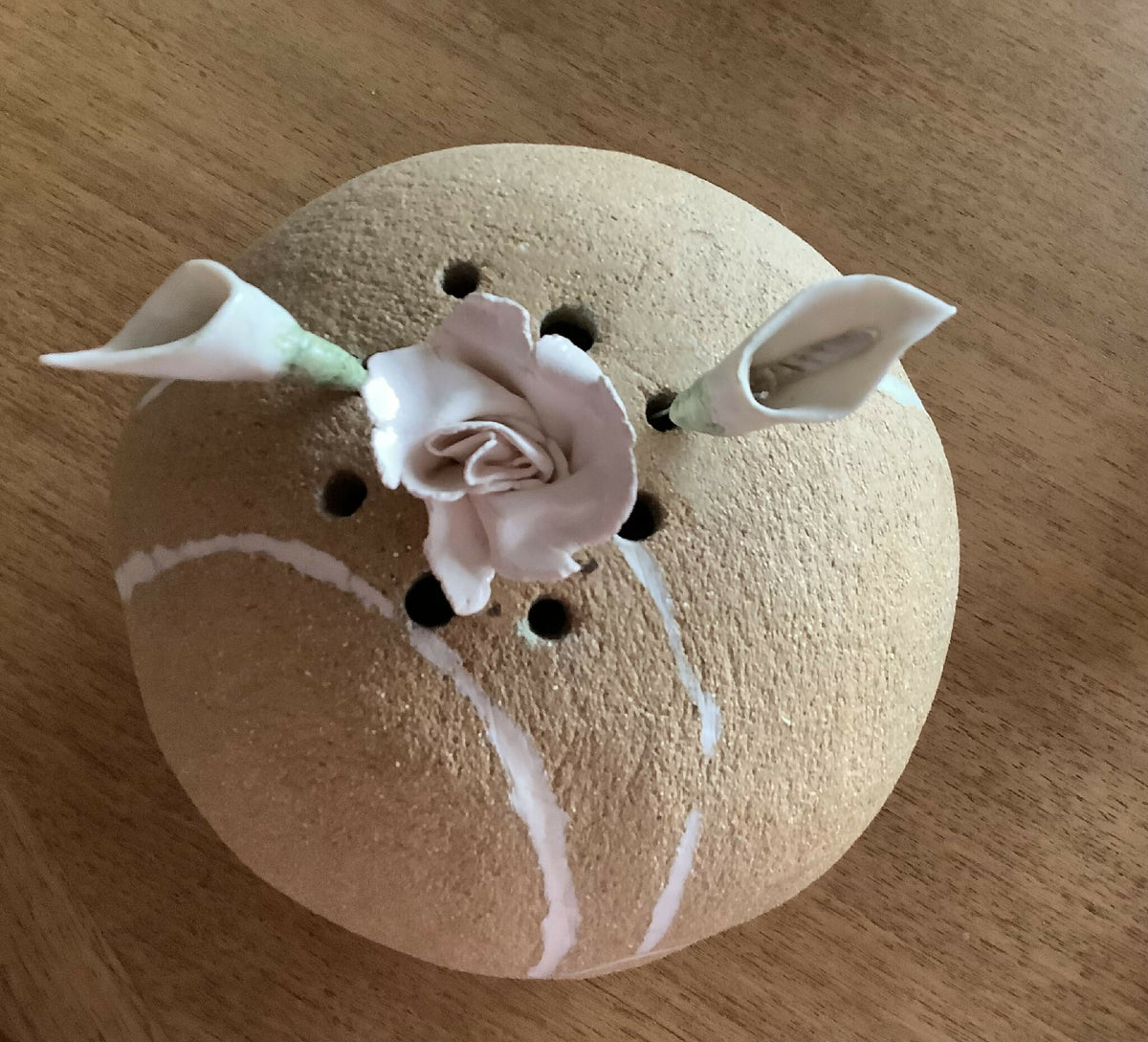 Vase rond beige vu de dessus, fleurs blanches en porcelaine et décor à traits