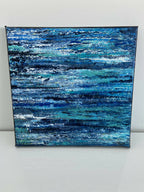 Tableau sur toile carrée, fond bleu avec rubans turquoise et éclats blancs.