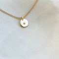 Collier à chaîne dorée et médaillon rond blanc nacré