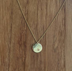 Collier à chaîne dorée et pendentif rond clair avec petit motif gravé