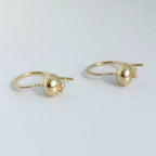 Paire de boucles d’oreilles créoles dorées avec petite pierre rouge