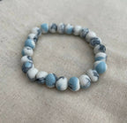 Bracelet femme en perles de porcelaine bleu clair et blanches, motif marbré.