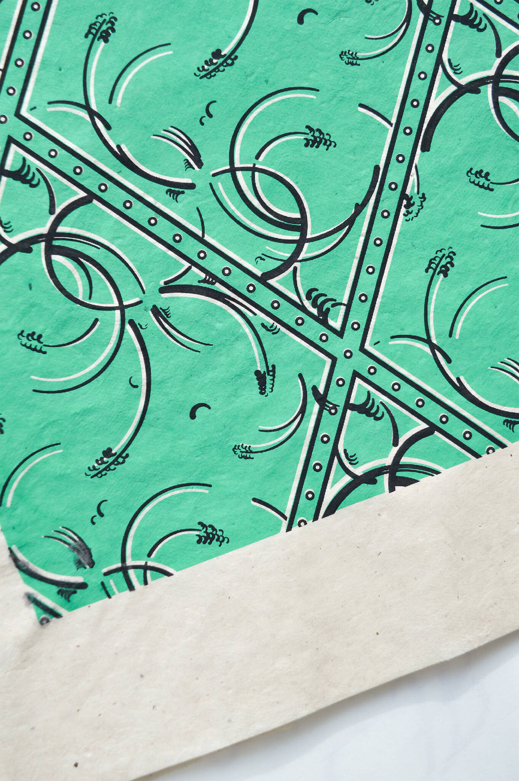 Coin de tissu vert émeraude, losanges à arabesques et bordure cloutée