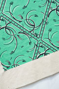 Coin de tissu vert émeraude, losanges à arabesques et bordure cloutée