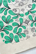 Coupon de tissu imprimé vert, motifs feuillages et fleurs stylisées, détails noirs