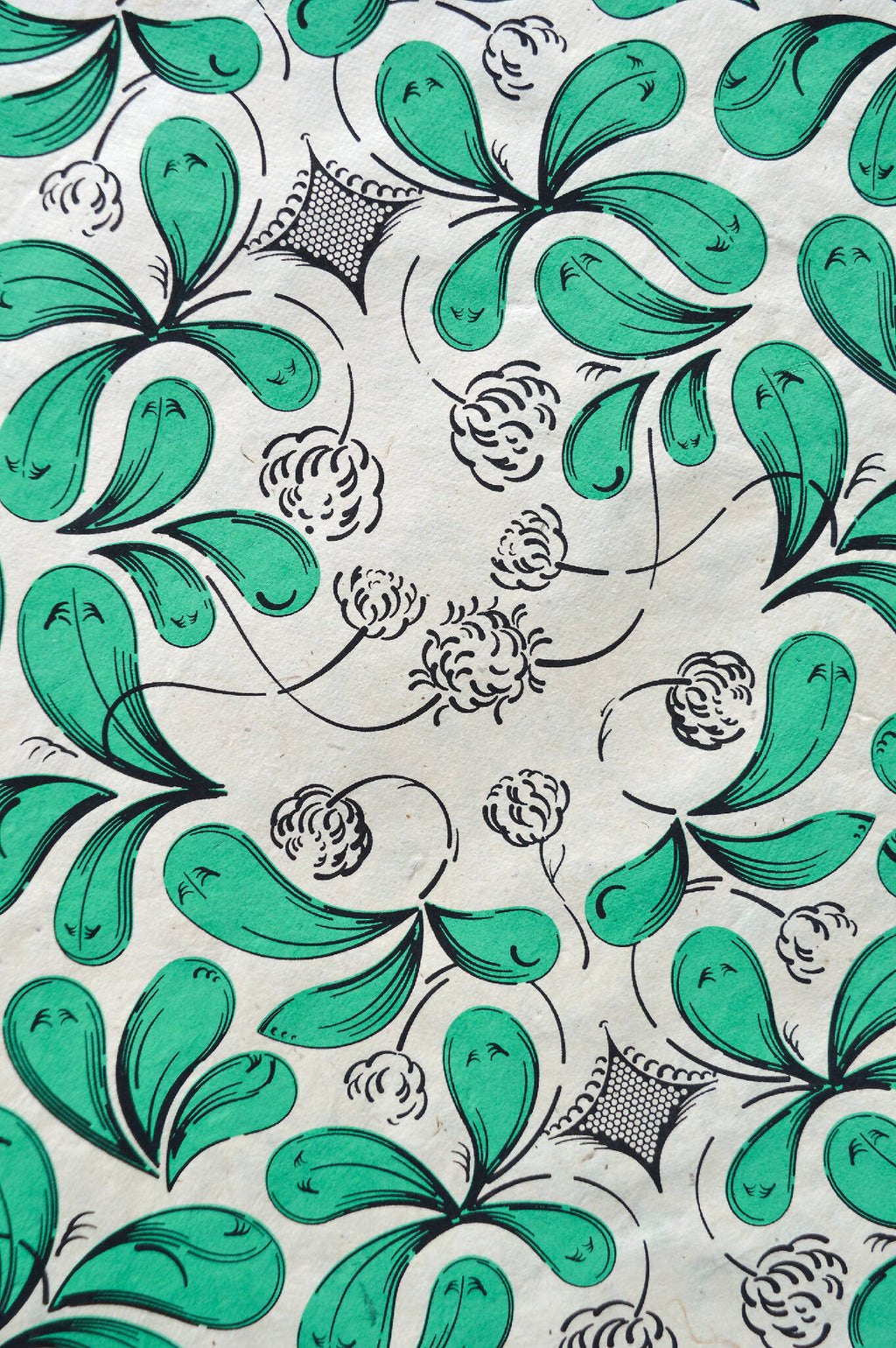 Coupon de tissu imprimé vert, feuilles et fleurs, contours noirs sur fond clair