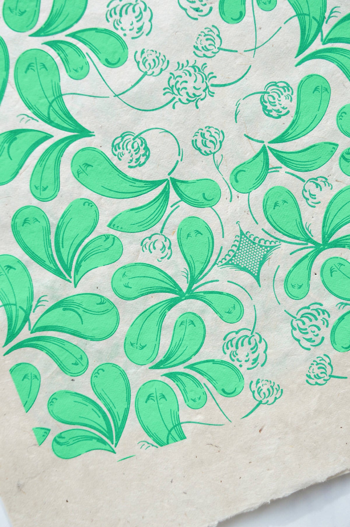 Coupon de tissu imprimé vert, motif feuillagé et fleurs, fond clair