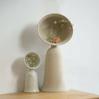 Vase soliflore beige avec bouquet de fleurs séchées, vue de face.