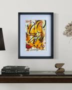 Tableau abstrait encadré, touches orange, jaune et noir.