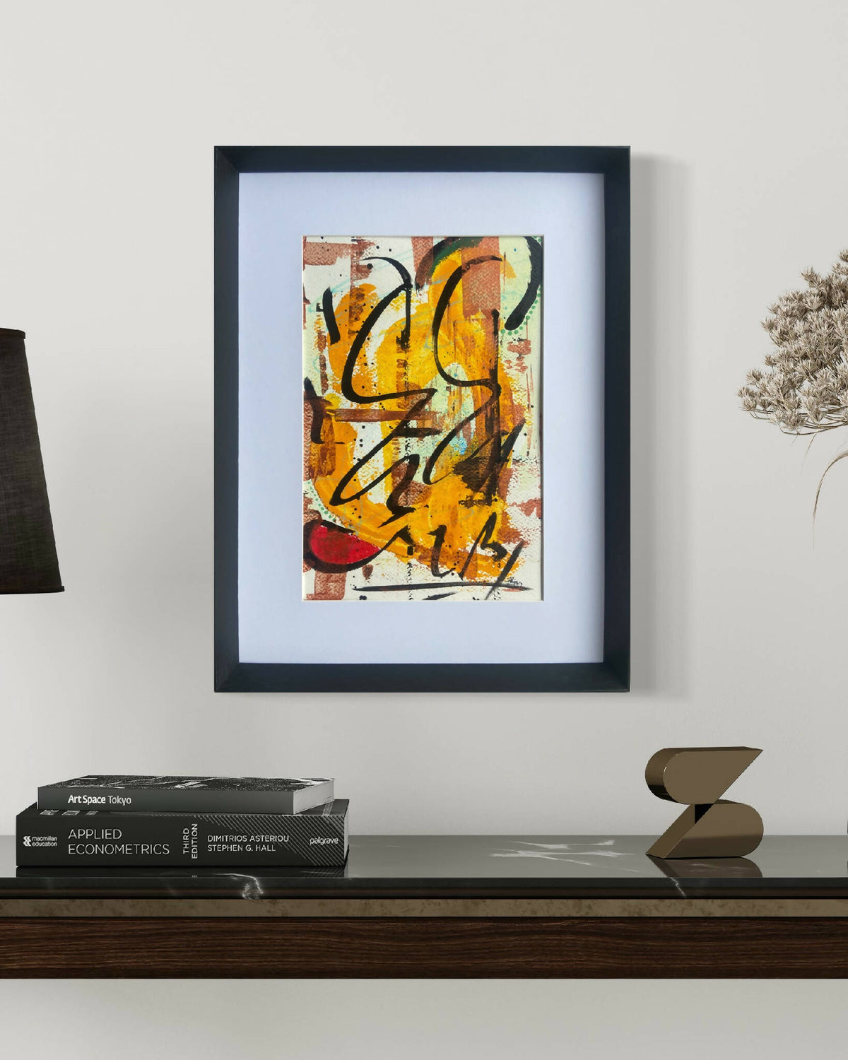 Tableau abstrait encadré, touches orange, jaune et noir.