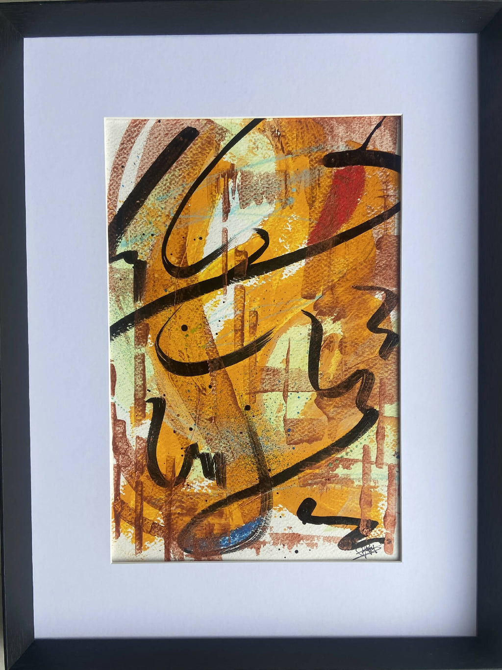 Œuvre abstraite encadrée en gros plan, motifs orange et noirs sur fond clair.
