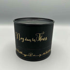 Boîte parfumée noire ronde avec couvercle et inscription dorée « Nez dans les Fleurs »