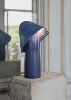 Lampe bleue à abat-jour conique sur socle rectangulaire, vue de côté