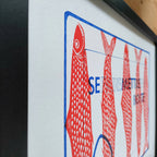 Gros plan d’une affiche encadrée : poissons rouges et motifs sur fond clair