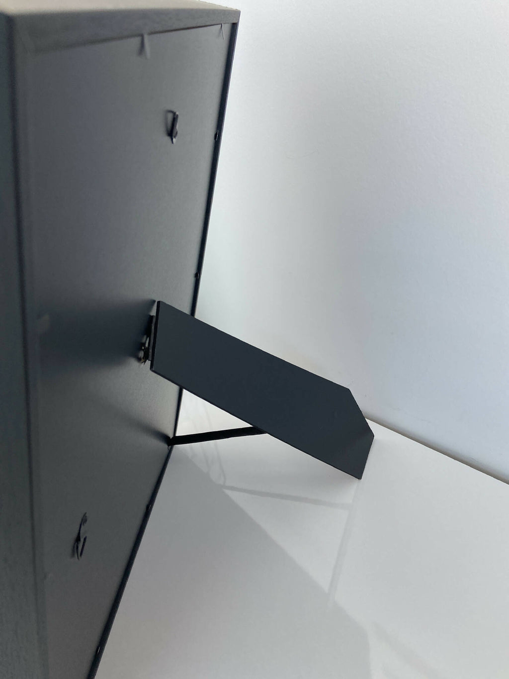 Dos de tableau encadré avec attache métallique noire pour suspension.