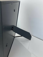 Dos de tableau encadré avec attache métallique noire pour suspension.