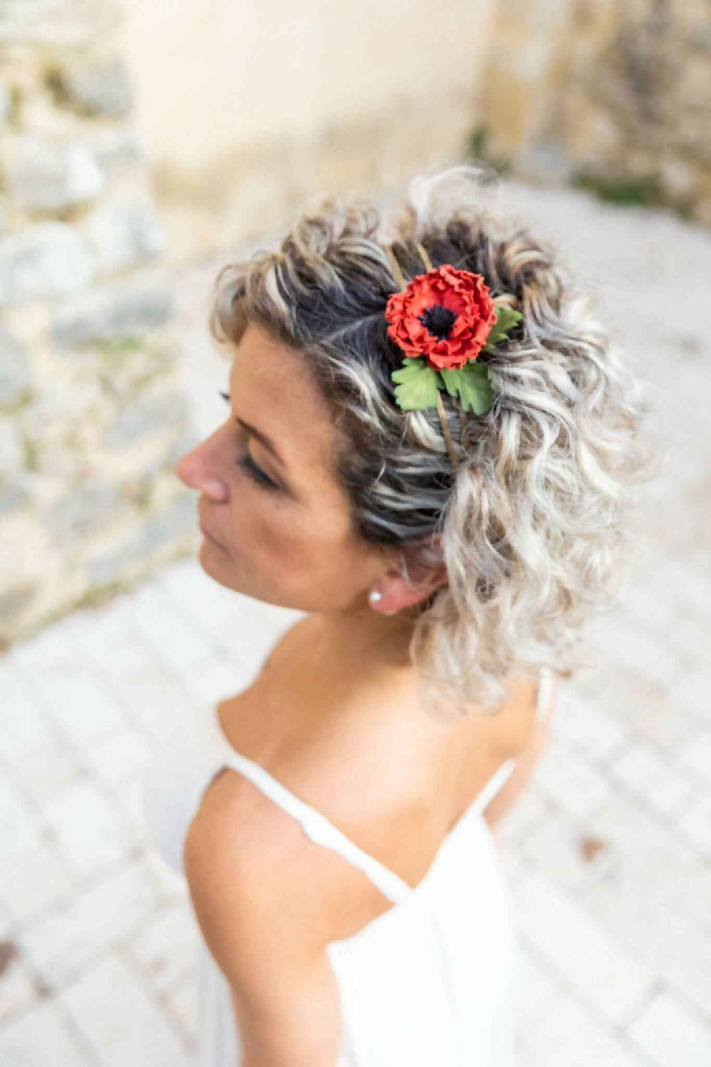 Serre-tête bucolique avec grande fleur rouge sur cheveux bouclés gris