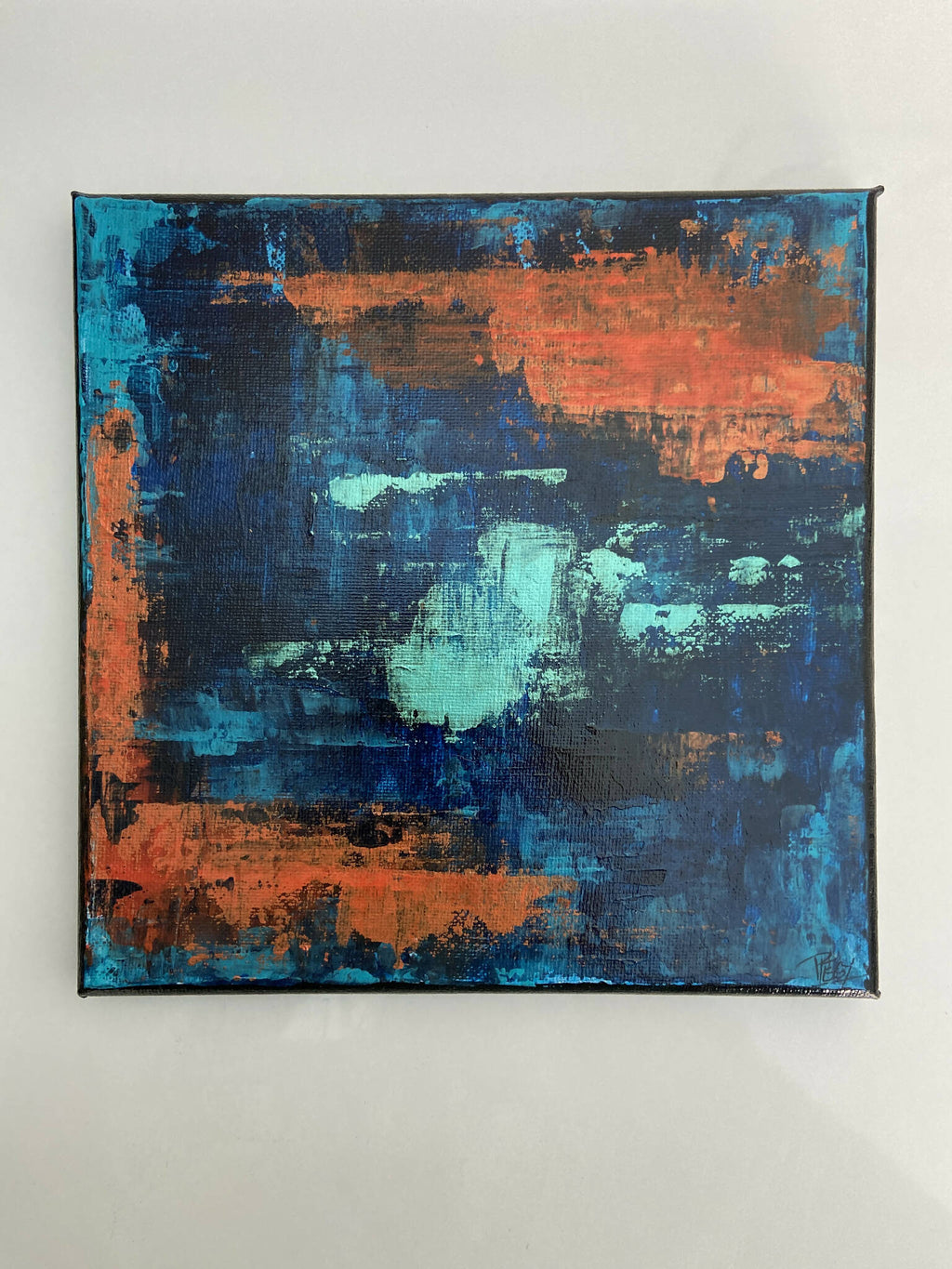 Tableau abstrait encadré, fonds bleu et orange, touches peintes texturées.