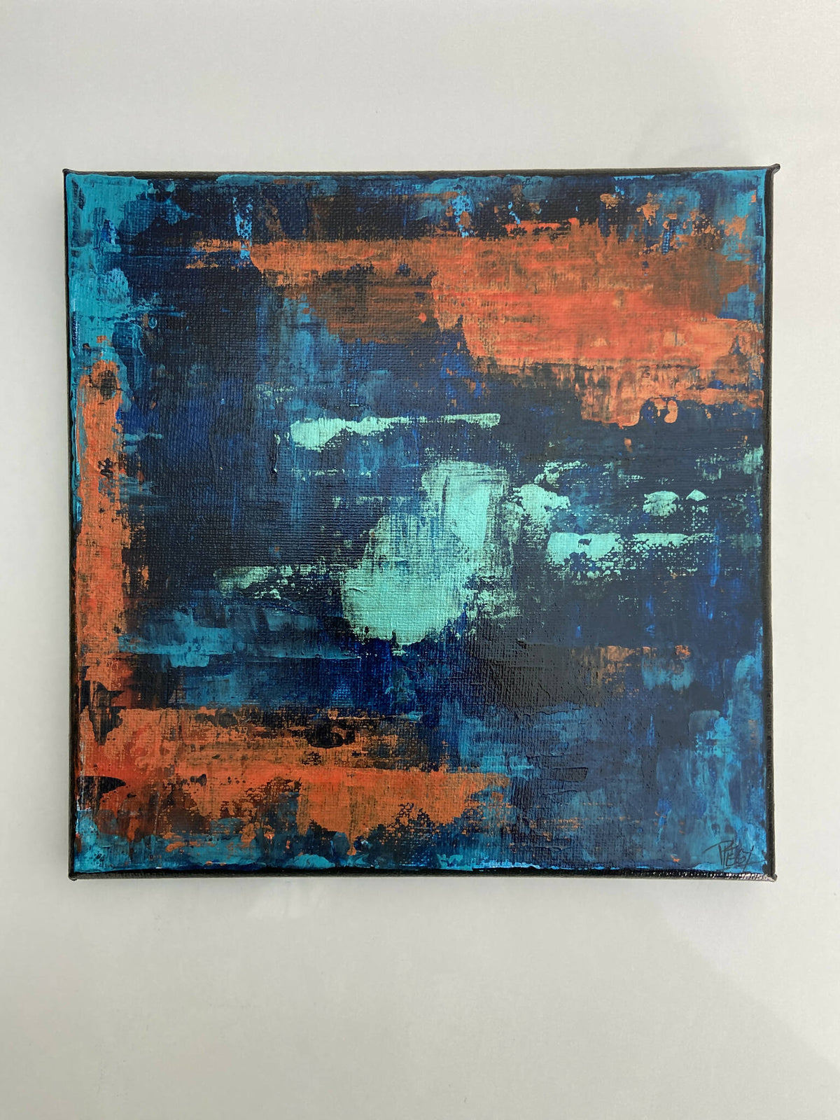 Tableau abstrait encadré, fonds bleu et orange, touches peintes texturées.