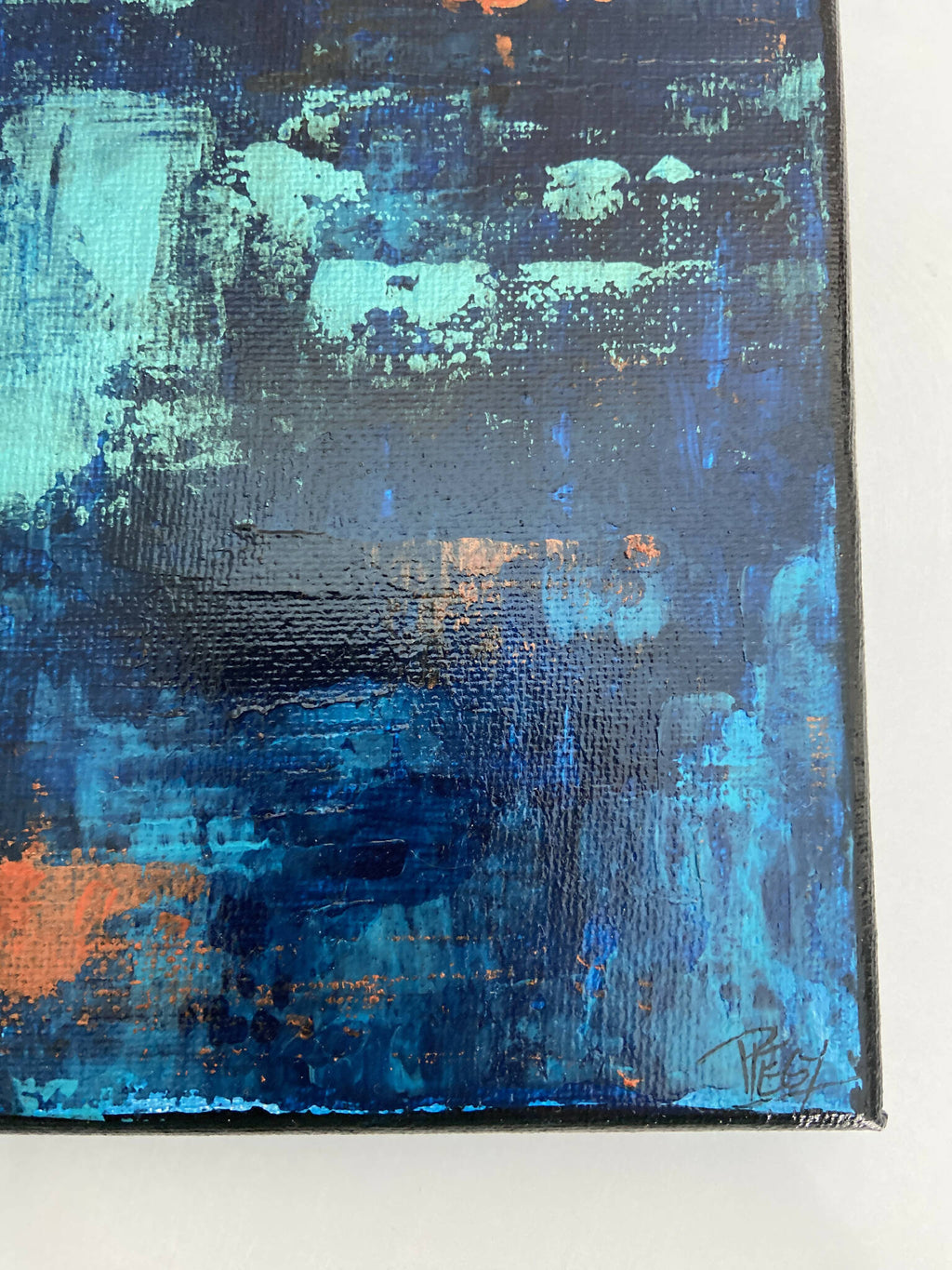 Tableau abstrait encadré, gros plan texture bleu avec accents turquoise et orange.